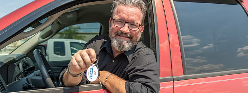 Customer Will Brown sitting in his truck holding Car-Mart keychain