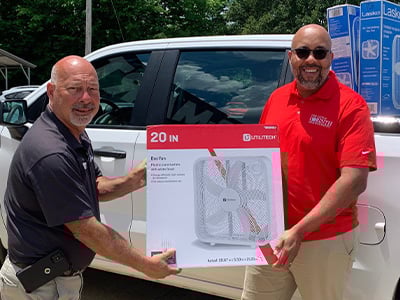 Car-Mart associates show off a donated fan.