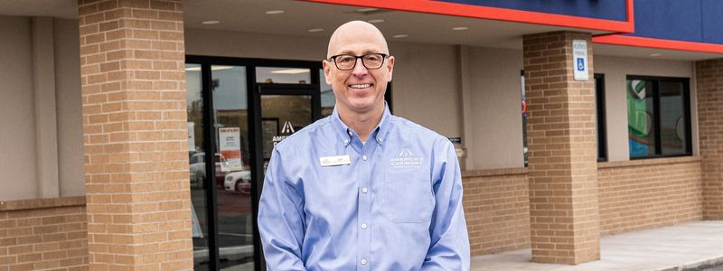 America's Car-Mart CEO Jeff Williams posing in front of Car-Mart dealership
