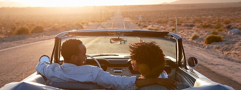 Man-woman-in-convertible-sunset