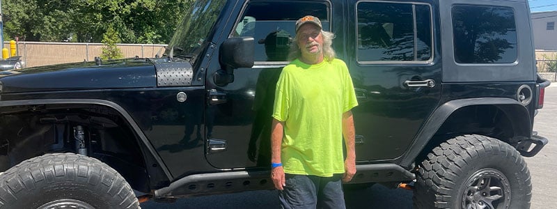 Car-Mart customer, Doug Childress, standing by his Jeep