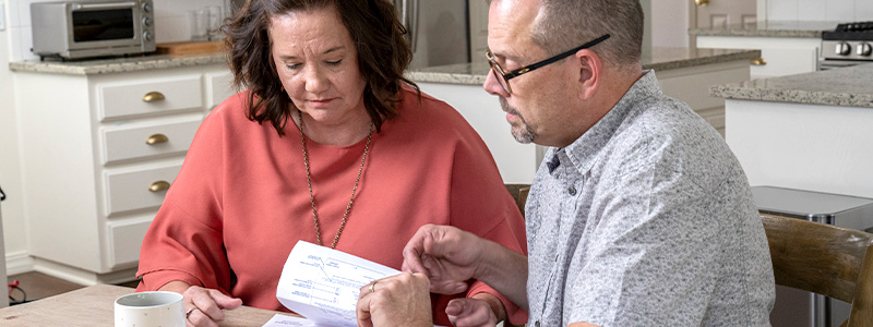 Man and wife at home looking over bills.