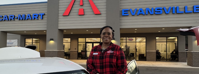 Denise Carver, General Manager at Car-Mart of Evansville, Ind. standing outside of a Car-Mart dealership with a white vehicle.